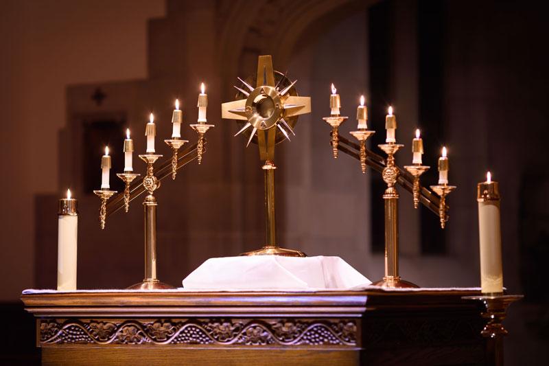 The Eucharist surrounded by candles on an altar